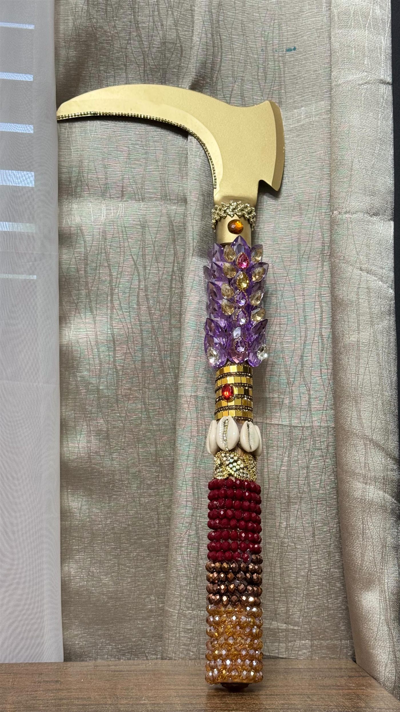 Hacha de Changó (oché) dorada, decorada con cristales morados y rojos